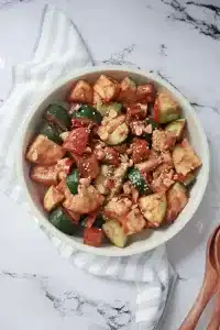 Top view of vegan Rojak salad with tofu and tropical fruits, sprinkled with sesame seeds and crushed peanuts