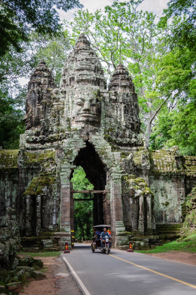 Imposing gates of Angkor Thom surrounded by lush jungle, leading to Bayon Temple