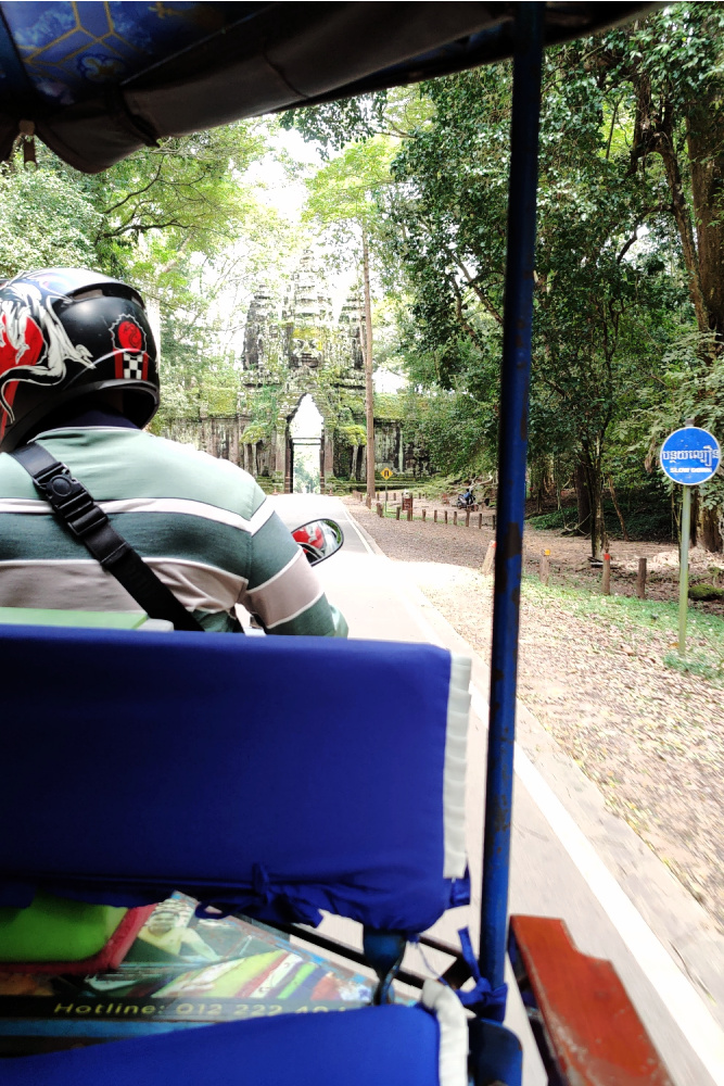 Tuk-tuk ride near Angkor Thom, offering a glimpse of local expertise and cultural connections during a day exploring Siem Reap.