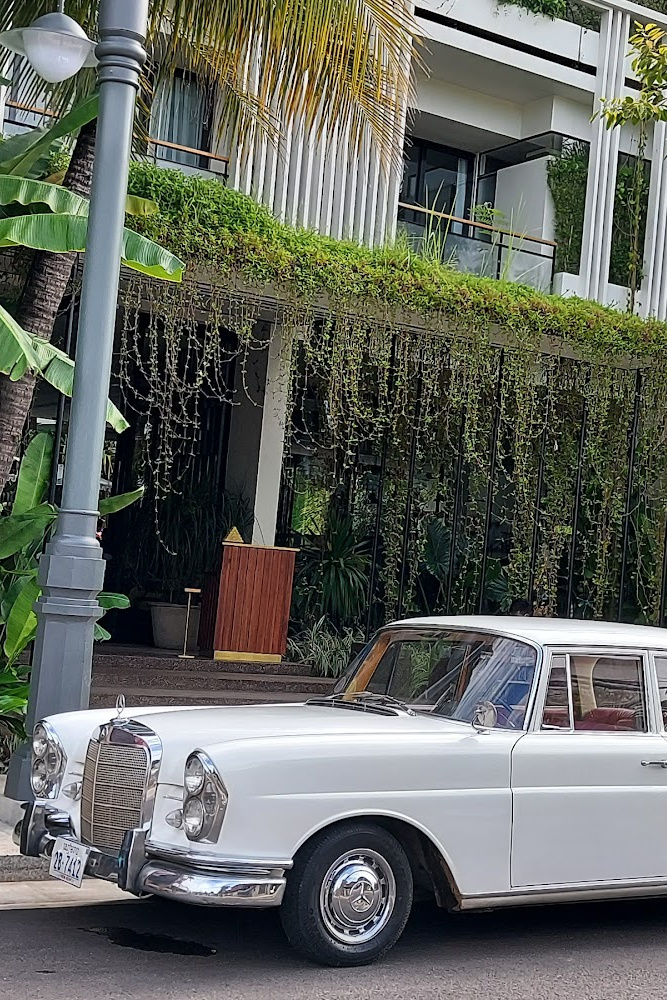 Vintage white car outside Viroths Hotel, used for a stylish airport transfer in Siem Reap