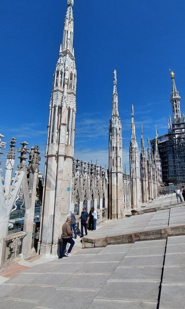 View of marble spires from the rooftop of the Duomo di Milano on a sunny day during our Italy itinerary 5 days by train.