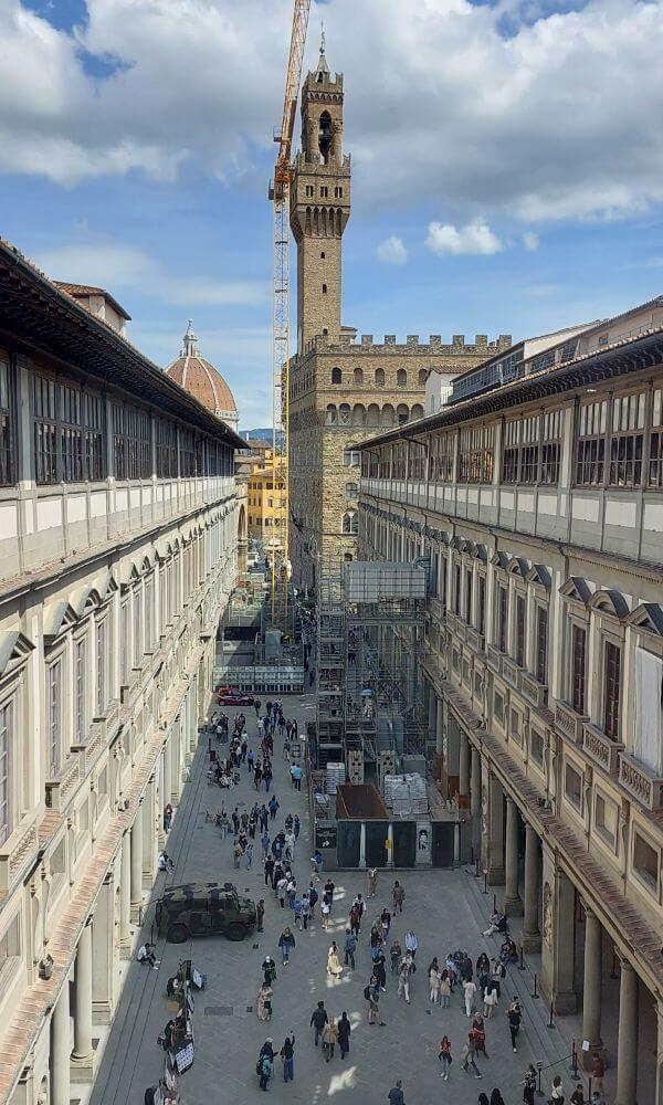 View of the Uffizi courtyard in Florence with the Palazzo Vecchio tower in the background.