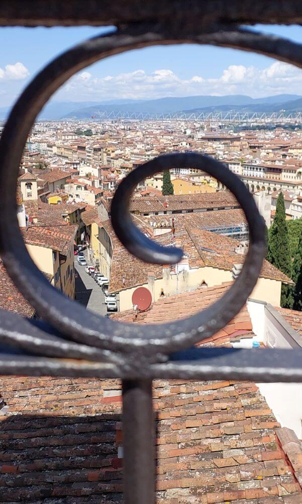 Artistic view of Florence rooftops framed by wrought iron rail from Giardino Bardini